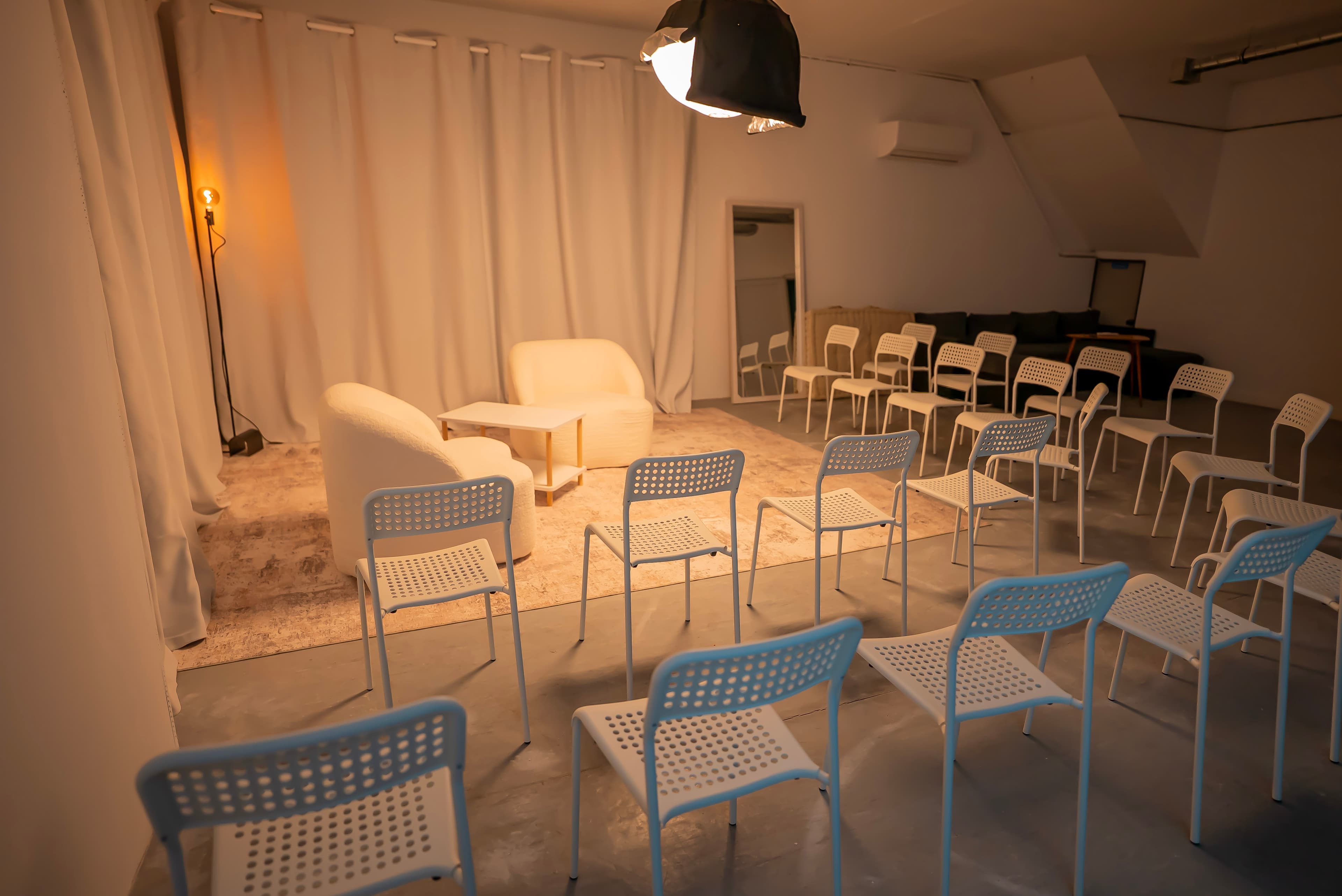 Event space in Lisbon with professional lighting, white armchairs and audience seating at Film Büro