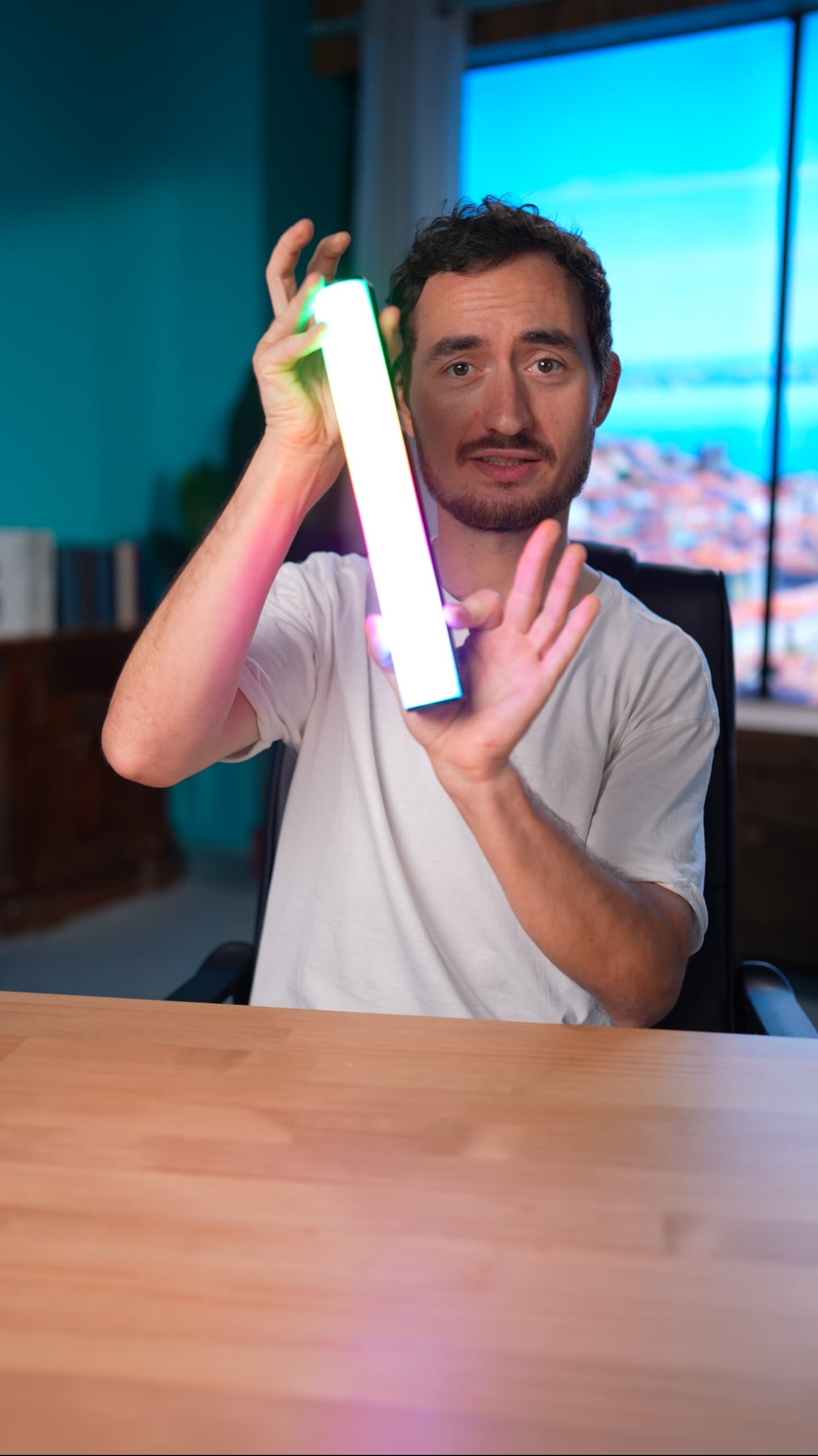 Creator demonstrating LED light panel with city skyline backdrop