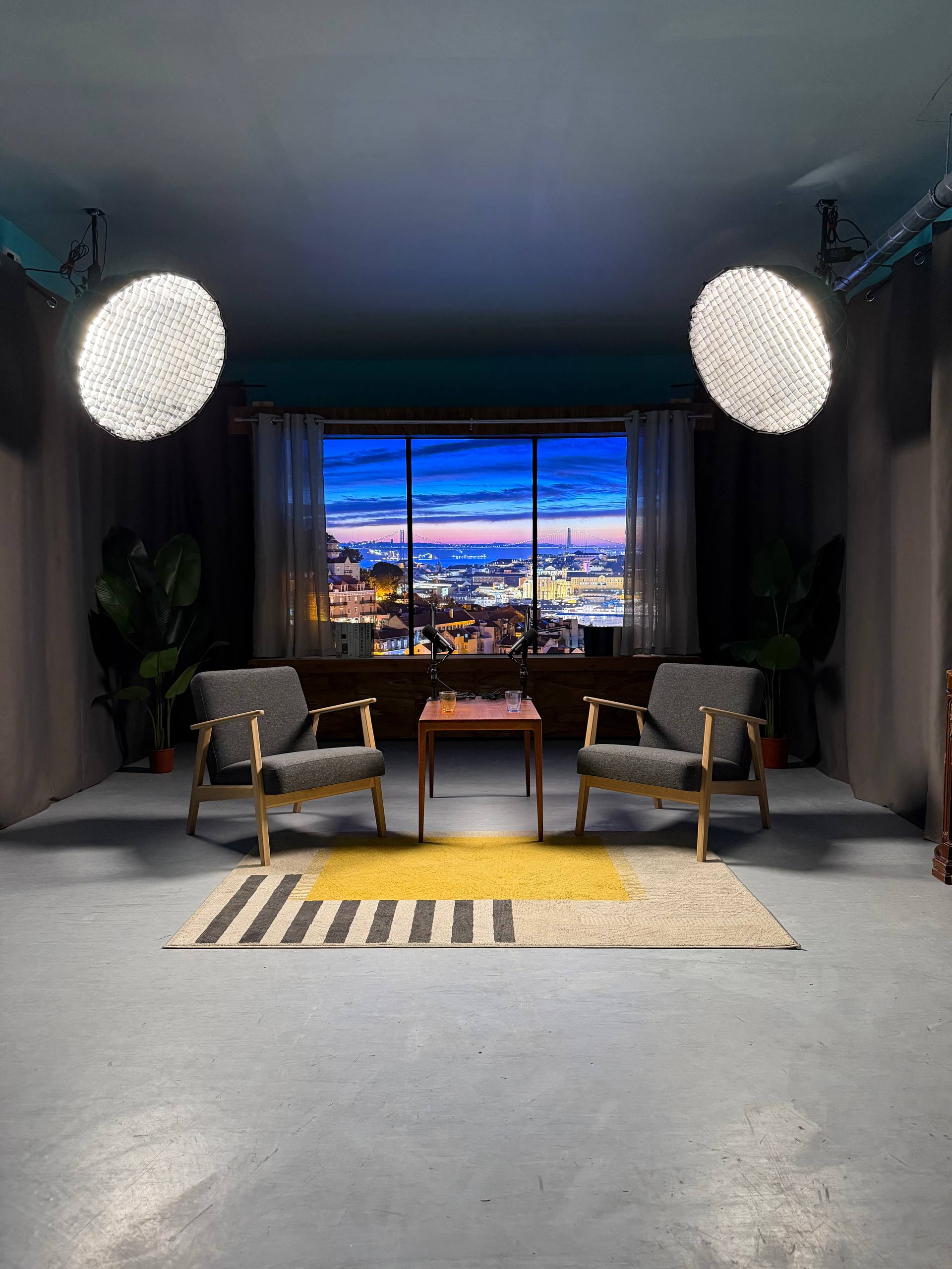 Film Büro video podcast studio in Lisbon with Infinite Digital Window Lisbon evening cityscape and 25 de Abril bridge