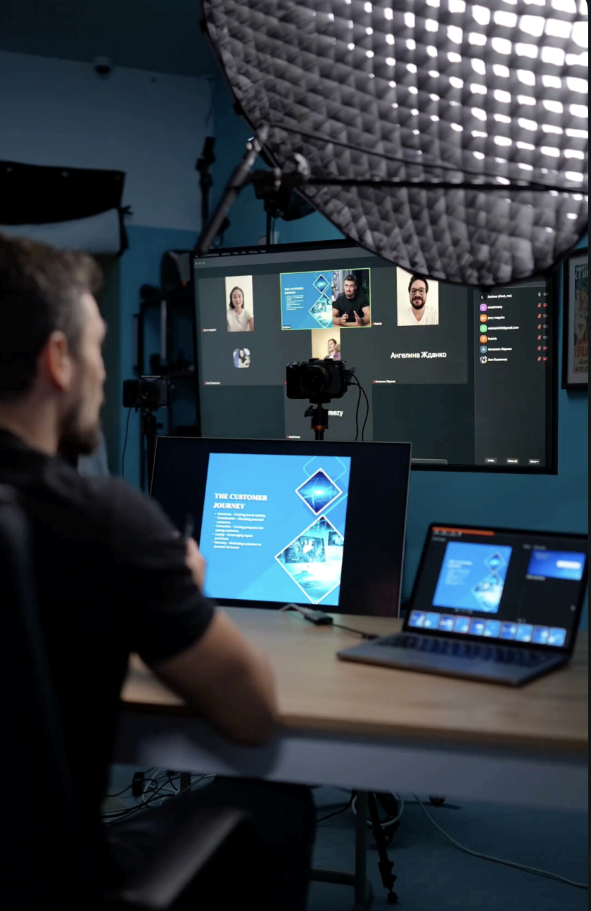 Behind the scenes of live webinar production at Film Büro Lisbon with multi-screen setup, camera, and live participants